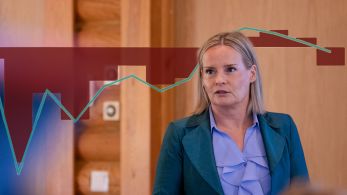 Kuva valtiovarainministeri Riikka Purrasta, jossa graafi julkisen talouden tasapainon vuosimuutoksesta.